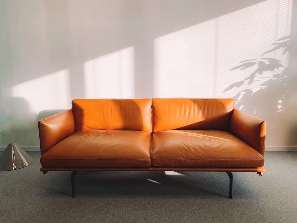 Sofá chaise longue gris tapizado en salón luminoso de Barcelona